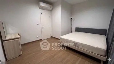Spacious bedroom with minimalist design and wooden flooring