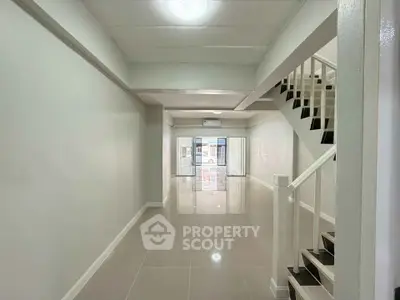 Spacious open-plan interior with modern staircase and glossy tiled floors, perfect for versatile living arrangements.