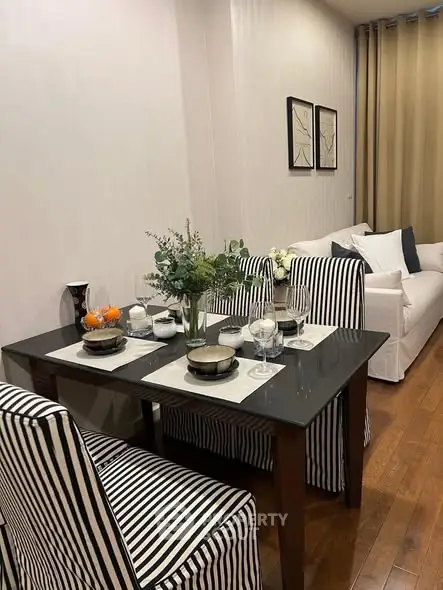 Stylish dining area with striped chairs and elegant table setting in modern living space.