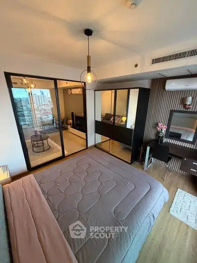 Modern bedroom with stylish decor and city view, featuring a cozy bed and sleek furniture.