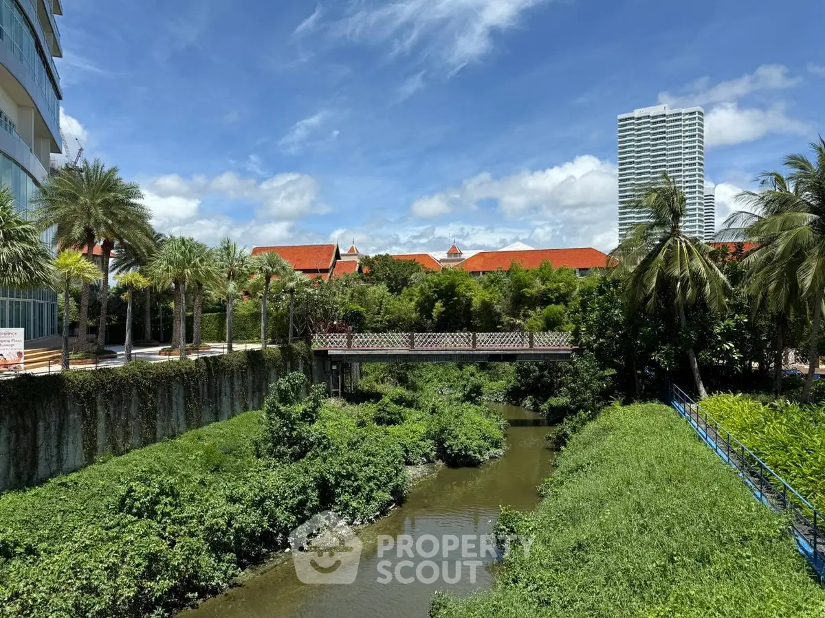 Scenic view of lush garden with modern buildings and blue sky
