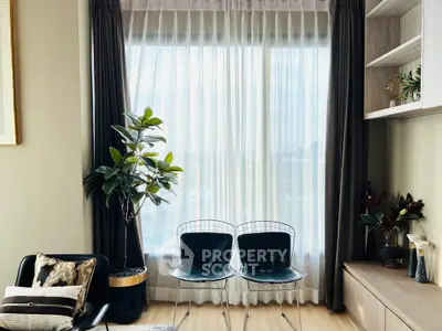 Modern living room with stylish chairs and large window with sheer curtains