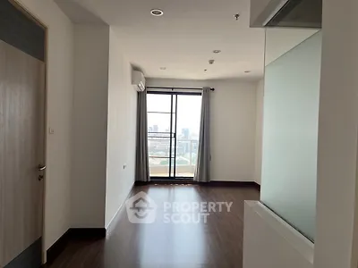 Spacious apartment interior with large window and city view, perfect for modern living.
