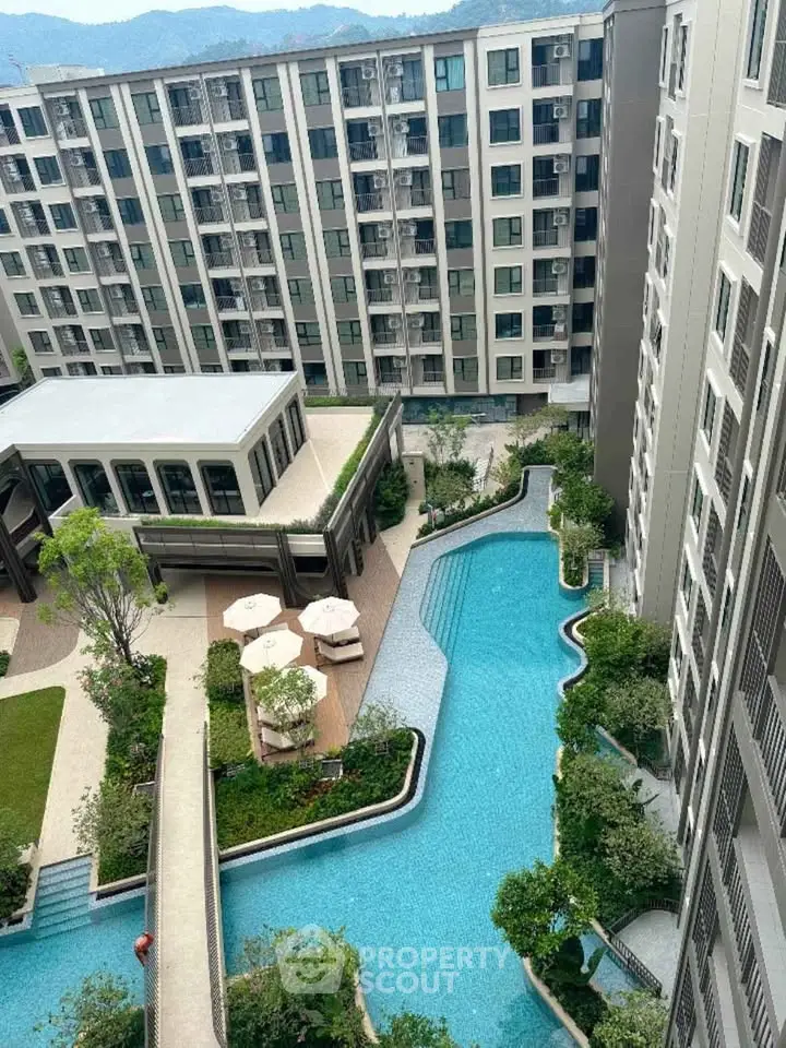 Luxurious apartment complex with stunning pool and lush garden views.