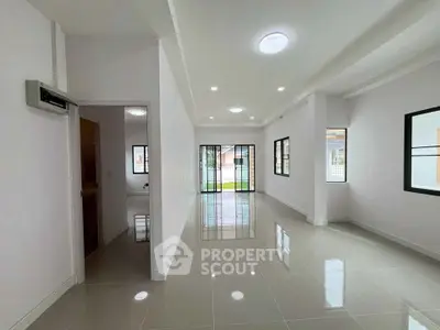 Spacious modern living room with glossy tiled floors and large windows for natural light.