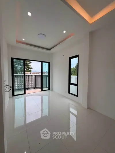Spacious modern living room with large windows and balcony access
