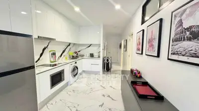 Modern kitchen with sleek white cabinets and marble flooring