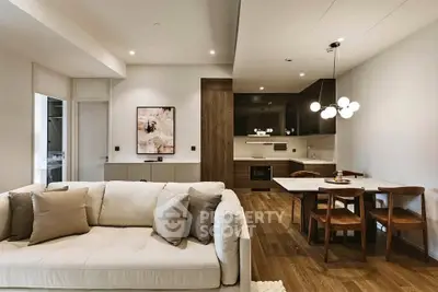 Modern open-plan living room and kitchen with elegant decor and wooden flooring.