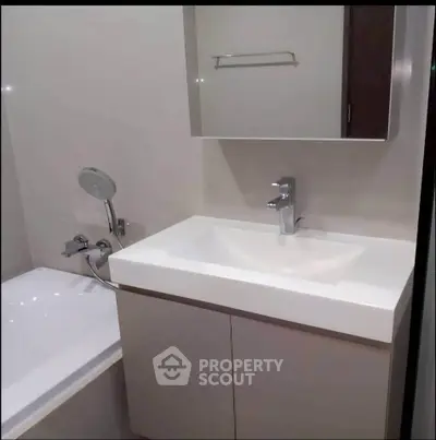 Modern bathroom with sleek sink and bathtub in contemporary apartment.