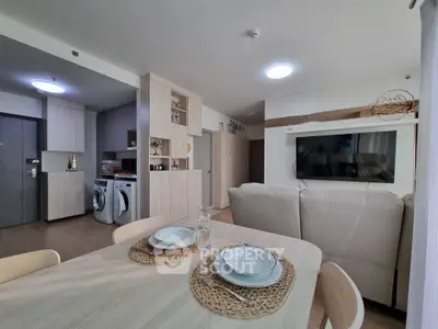 Modern open-plan living room with dining area and laundry appliances