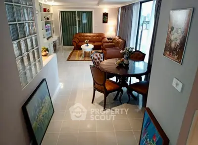 Spacious living room with elegant leather furniture and dining area, perfect for entertaining.