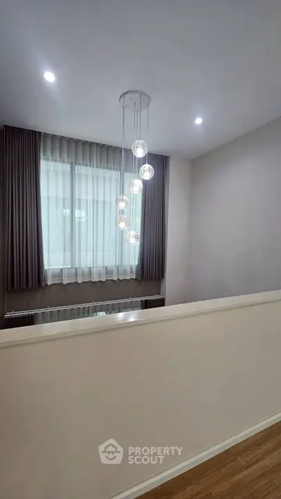 Modern interior with elegant lighting and floor-to-ceiling curtains in a stylish living space.