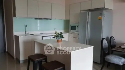 Modern kitchen with sleek cabinetry, island, and appliances in a stylish apartment.