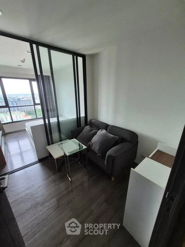 Modern compact living room with glass partition and city view.