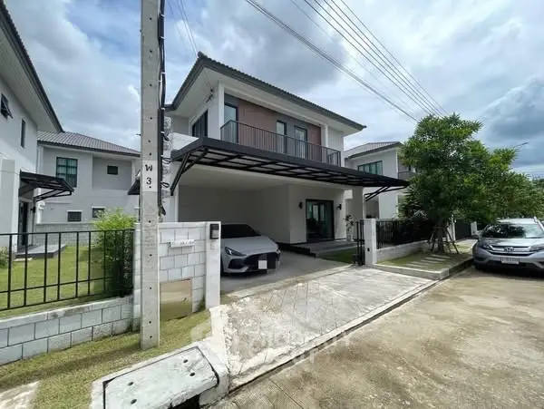 Modern two-story house with carport and landscaped yard in a suburban neighborhood.