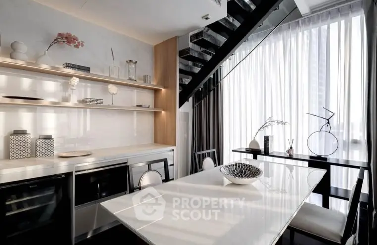 Modern dining area with sleek table, stylish decor, and large window for natural light.