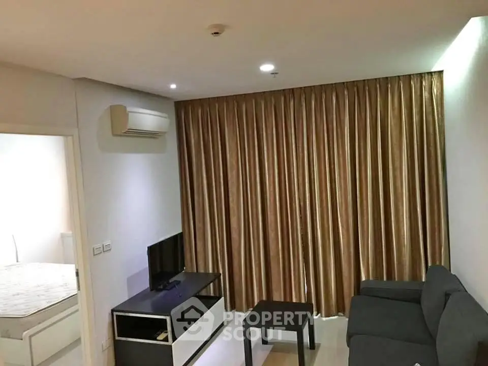 Modern living room with sleek furniture and elegant curtains in a cozy apartment setting.