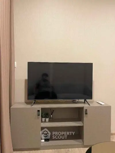 Modern living room with sleek TV stand and flat-screen TV, perfect for entertainment setup.