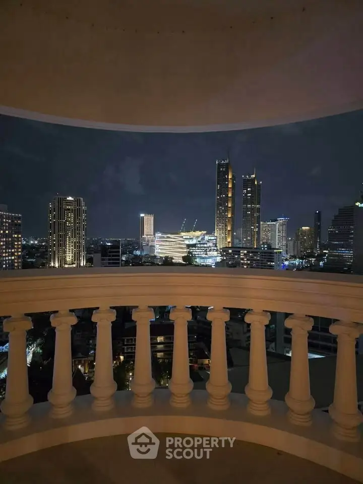 Stunning cityscape view from a balcony with elegant balustrade at night.