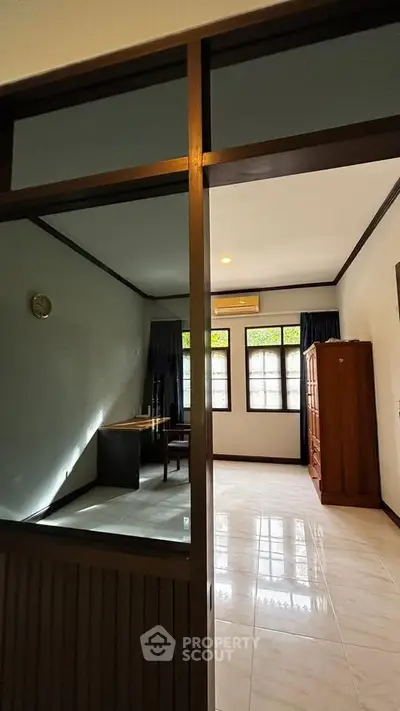 Spacious bedroom with natural light and wooden furniture