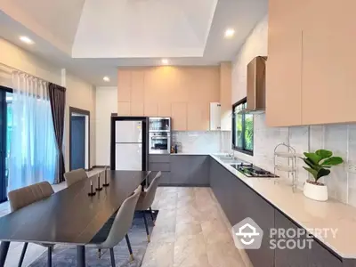 Spacious modern kitchen with sleek countertops, high-end appliances, and an adjoining dining area, perfect for entertaining.