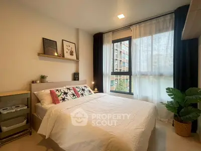Cozy bedroom with modern decor and large window offering natural light
