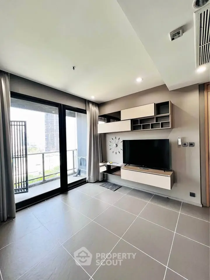 Modern living room with sleek TV unit and large balcony access