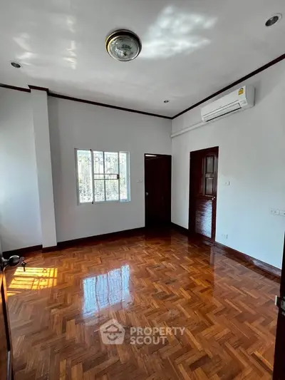 Spacious room with polished wooden floors and air conditioning