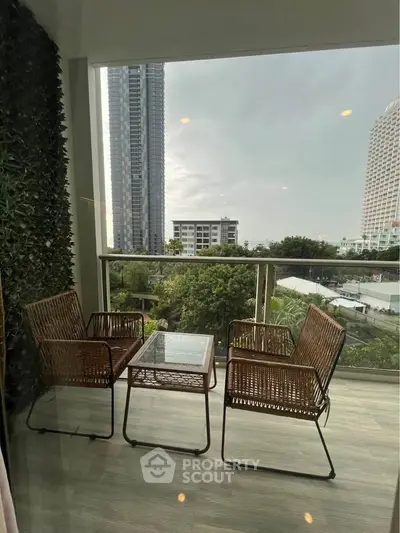 Chic balcony with wicker furniture and city view, perfect for relaxation.
