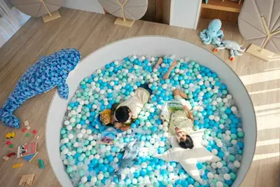 Charming children's play area with ball pit and plush toys in modern home.