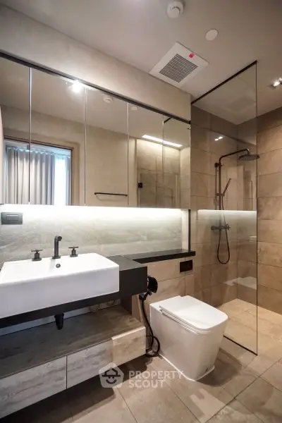 Modern bathroom with sleek design, glass shower, and elegant fixtures.
