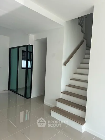 Modern interior with sleek staircase and glossy tiled flooring
