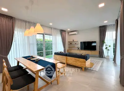 Spacious modern living room with dining area, large windows, and stylish decor.