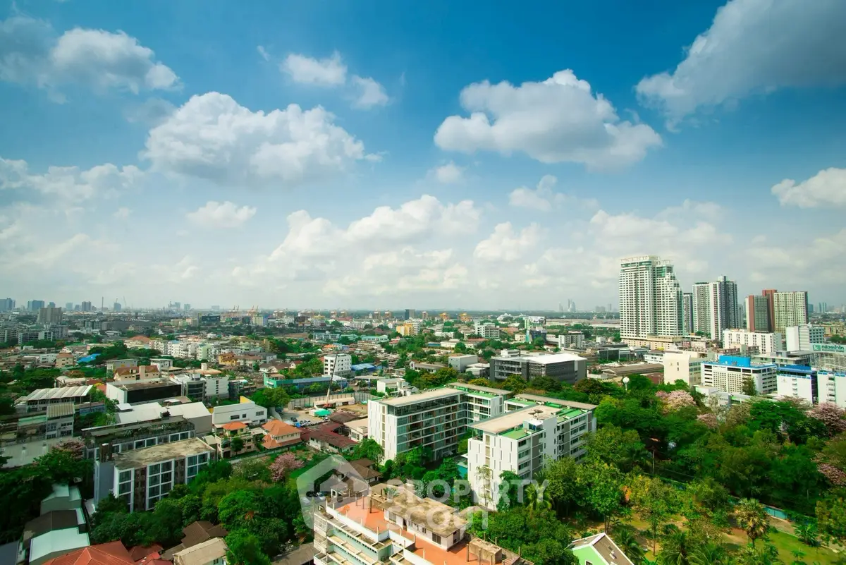 Stunning cityscape view with lush greenery and modern buildings under a clear blue sky.