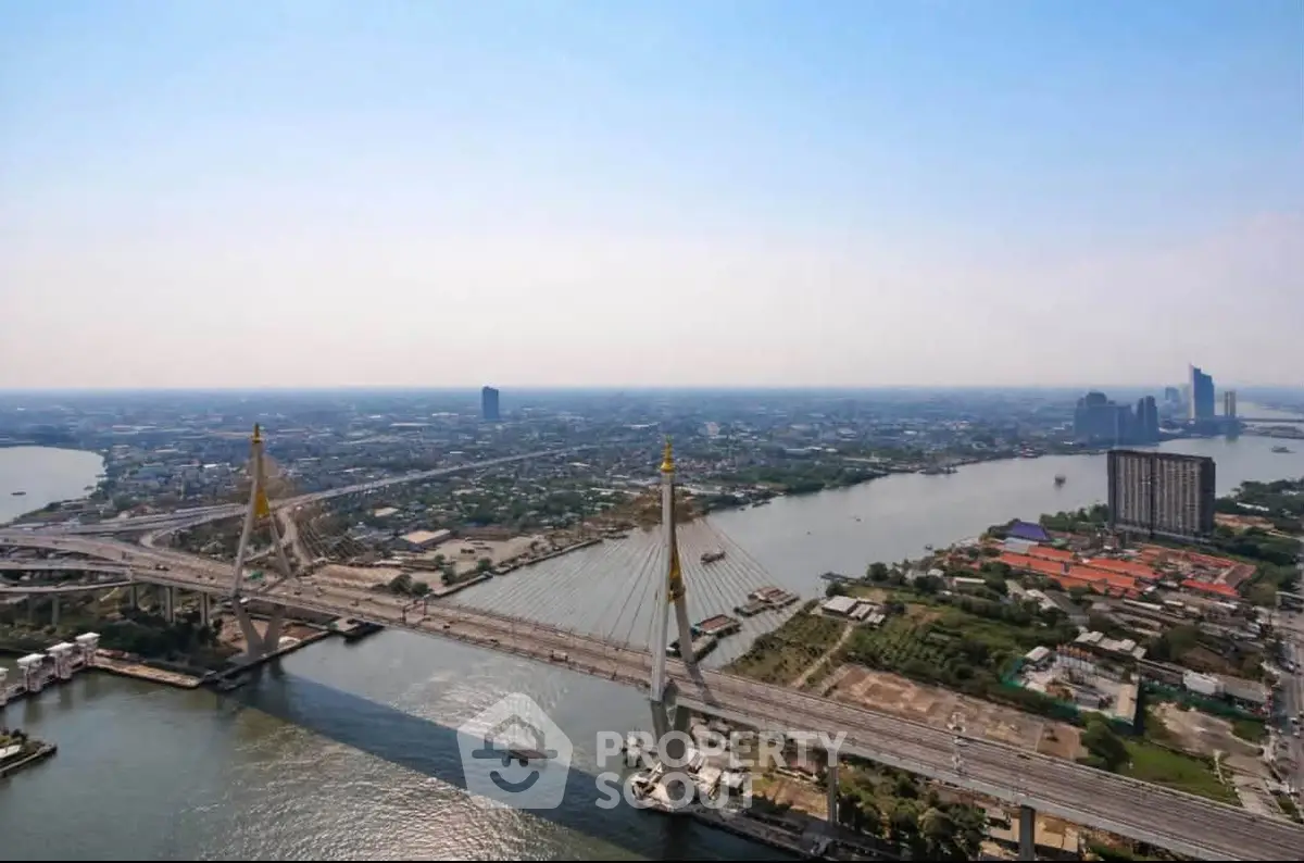 Stunning aerial view of a cityscape with a prominent bridge and river, showcasing urban development and skyline.