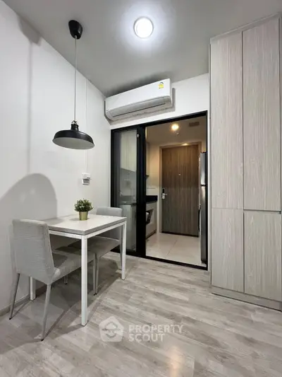 Modern kitchen with sleek design, featuring a dining area and air conditioning, perfect for cozy meals.
