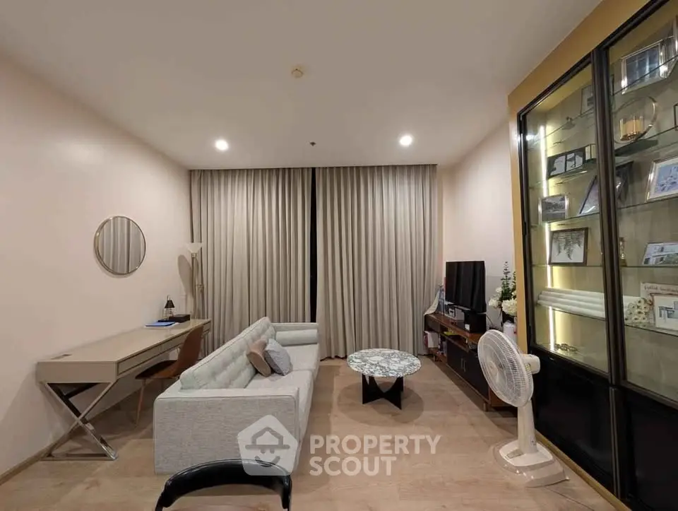 Modern living room with stylish furniture and elegant decor, featuring a cozy sofa and a sleek TV setup.