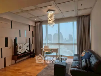Luxurious living room with modern decor and city view, featuring elegant chandelier and stylish furniture.
