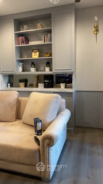 Elegant living room with plush sofa and built-in shelving, perfect for modern comfort and style.