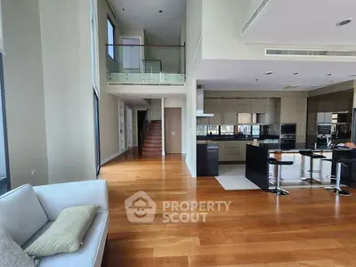 Luxurious open-plan living room with high ceilings and modern kitchen in a spacious apartment.