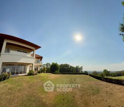 Stunning modern home with expansive garden and breathtaking view under clear blue sky.