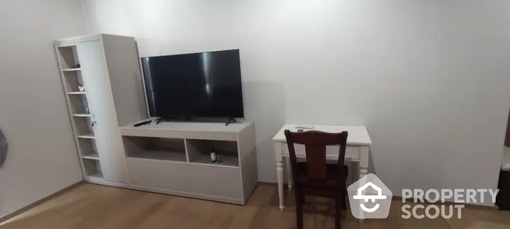 Modern living room with sleek TV stand and cozy desk setup.