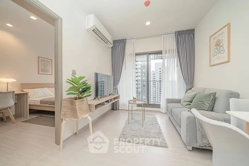 Modern living room with cozy decor and city view, featuring a stylish sofa and wall-mounted TV.
