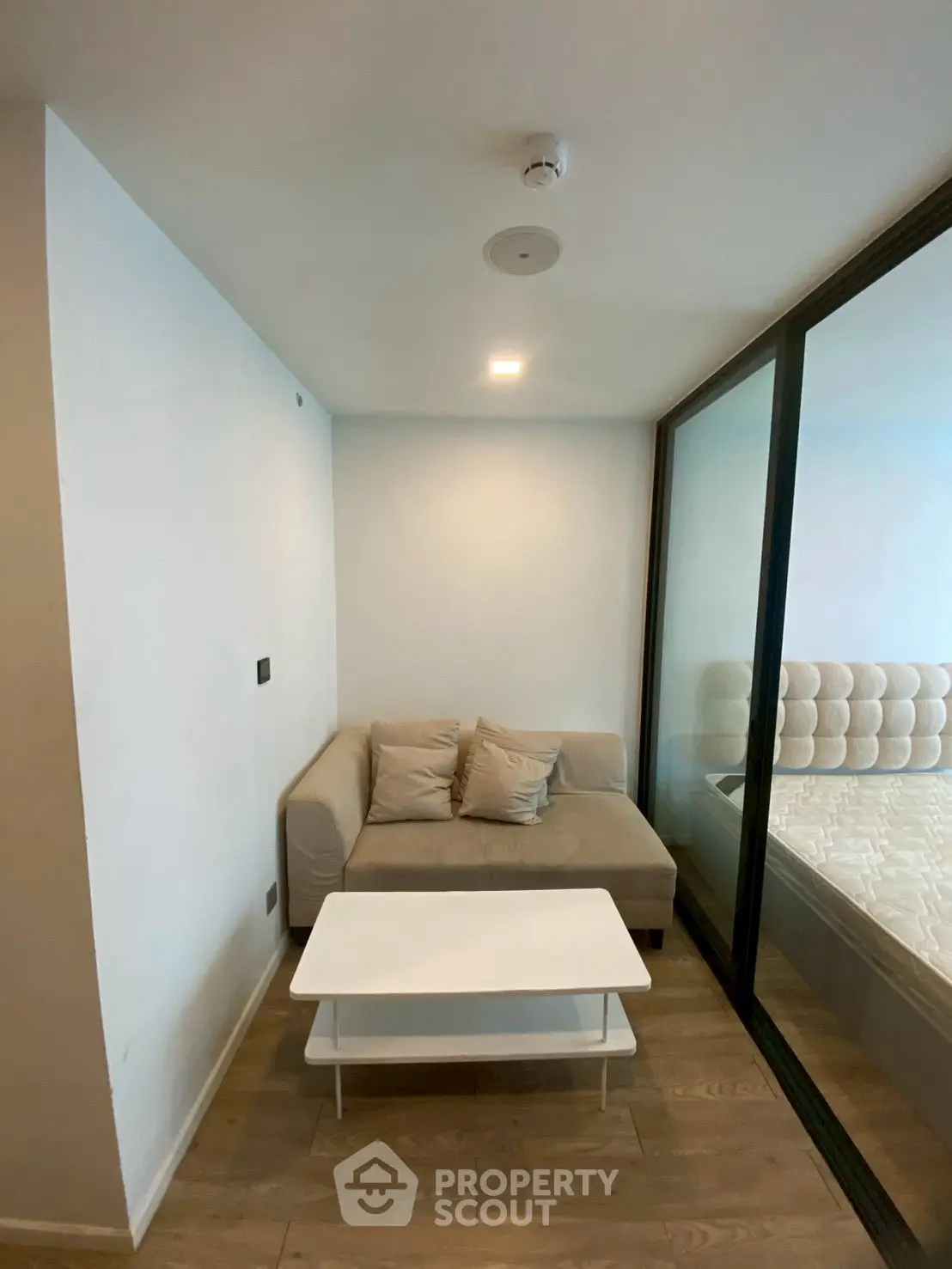 Cozy modern living area with sofa and glass partition in stylish apartment