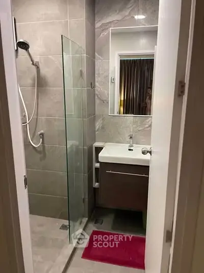 Modern bathroom with sleek shower and stylish vanity in contemporary apartment.