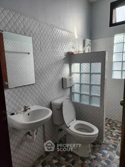 Charming bathroom with unique tile design and glass block accents.