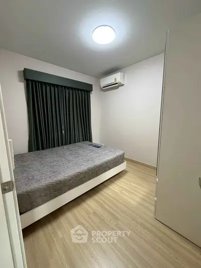 Modern bedroom with minimalist design, featuring a comfortable bed and air conditioning.