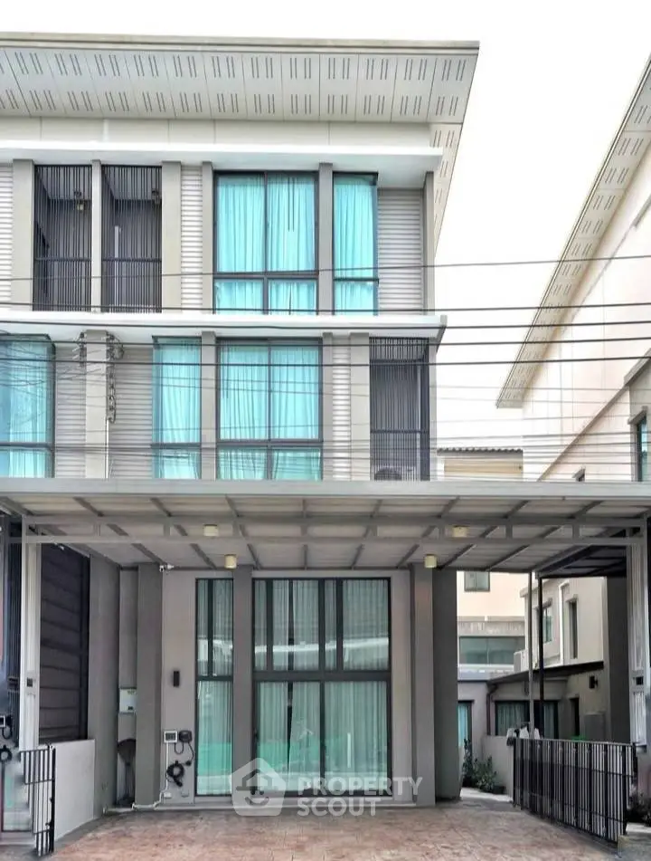 Modern multi-story townhouse with sleek design and large windows in urban setting.