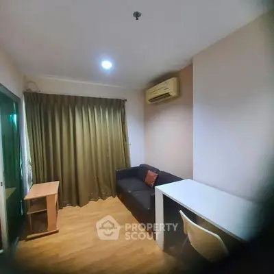 Cozy study room with wooden flooring, sofa, desk, and air conditioning.