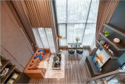 Luxurious high-ceiling living room with modern decor and panoramic city view.